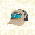 The Sendero Provisions Fly Fisher Mesh Cap is a tan and black trucker hat showcasing a patch with a fish leaping out of water and the text "Sendero Provisions Co." on the front, complete with a snapback closure for the perfect fit.