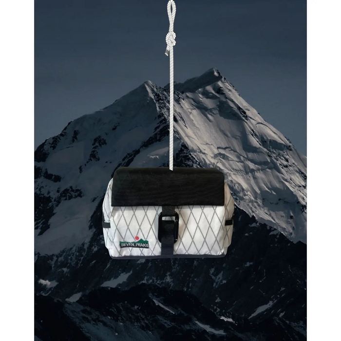 Forager Provisions LTD Seven Peaks black and white water-resistant fanny pack hanging against a mountain backdrop.