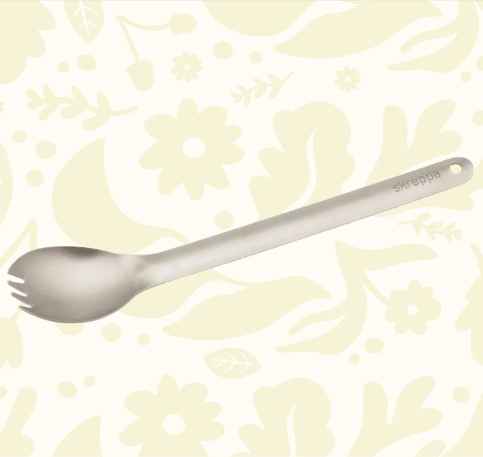 Skreppa Long Handle Titanium Spork, ultra-light raw titanium utensil with end hole, displayed on white for camping gear buyers.