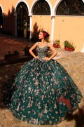 A woman wears a voluminous emerald/gold ball gown with floral pattern, standing in an arched courtyard.