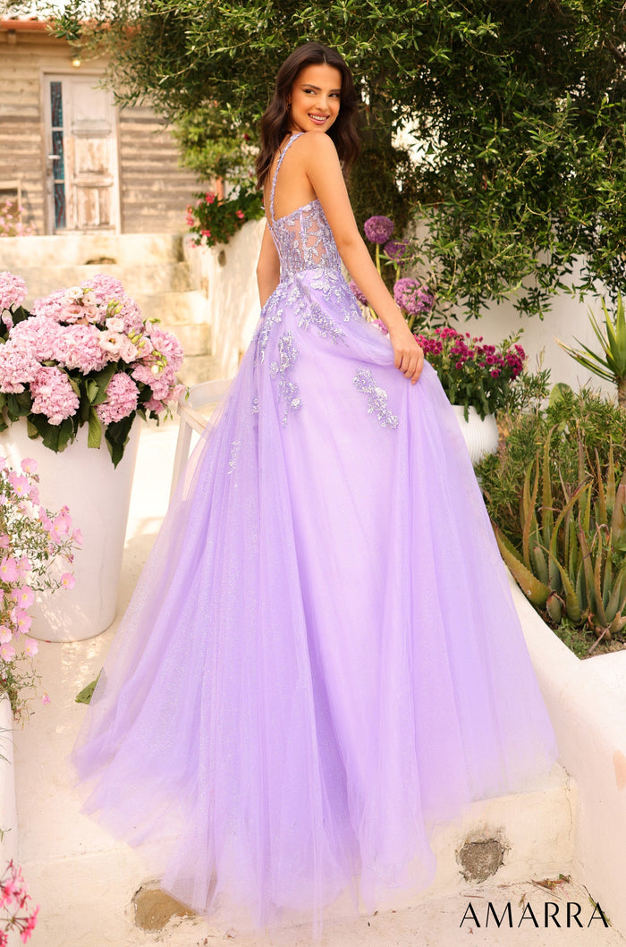 A lavender ballgown with floral appliqués stands against a garden backdrop with pink hydrangeas.