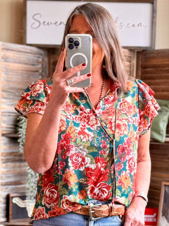 Floral V-neck flutter-sleeve shirt on teal ground with multicolor rose print