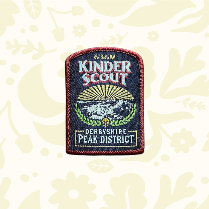 Kinder Scout Patch from The Adventure Patch Company’s Fells Series on rustic scratched wood; embroidered hiking badge.