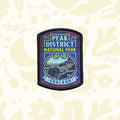 Peak District National Park patch by The Adventure Patch Company with mountain scene and leaves on wood background.