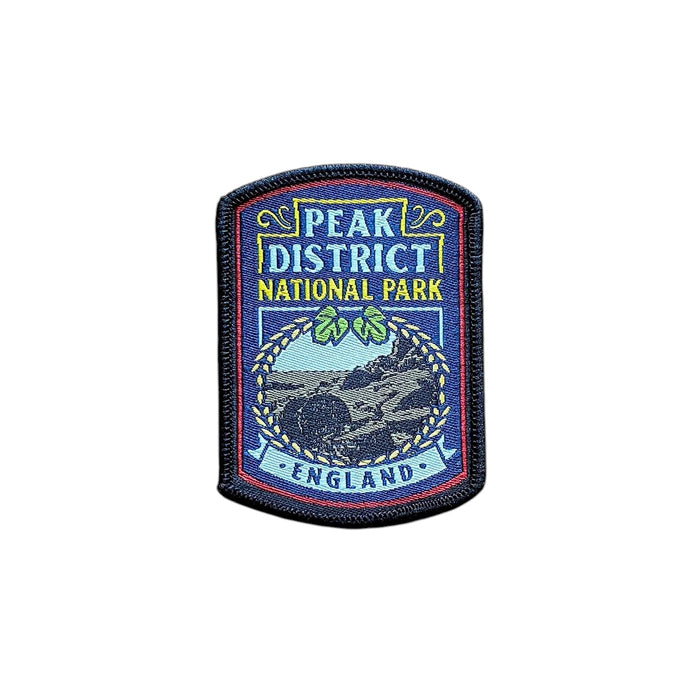 Forager Provisions LTD Peak District National Park embroidered patch with landscape design on a wooden background.