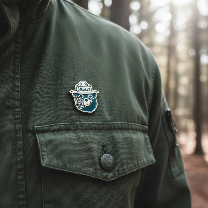 Smokey Bear enamel pin by The Landmark Project—wildfire prevention, Smokey logo collectible for outdoor enthusiasts.