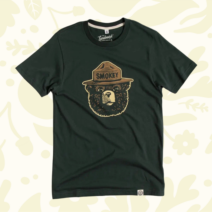 Forager Provisions LTD pine green unisex t-shirt featuring the classic Smokey Bear logo graphic on the chest.