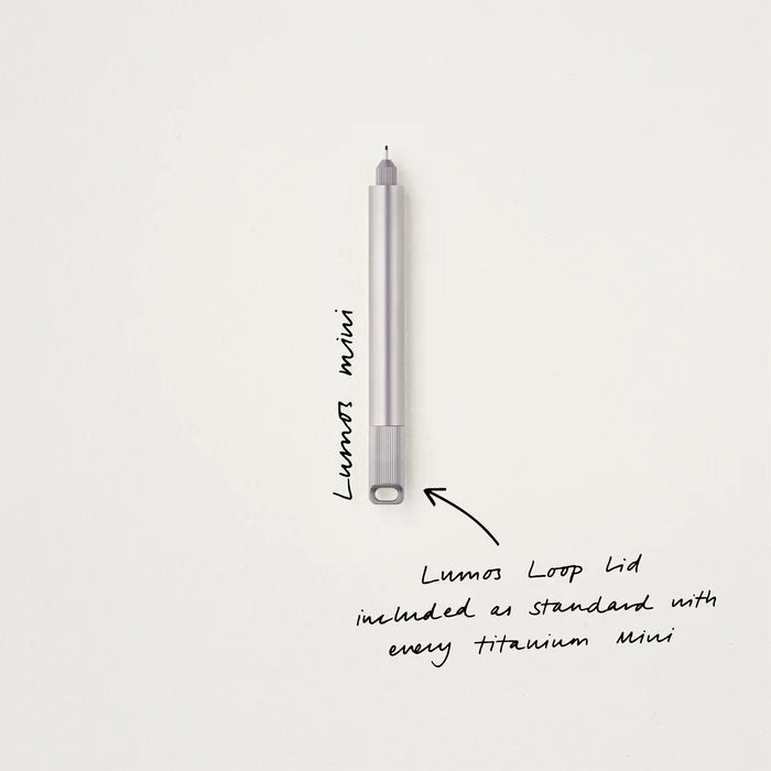 Tom’s Studio Lumos Mini Titanium pen stands upright with loop lid—sleek, durable, and perfect for elegant everyday writing tasks.