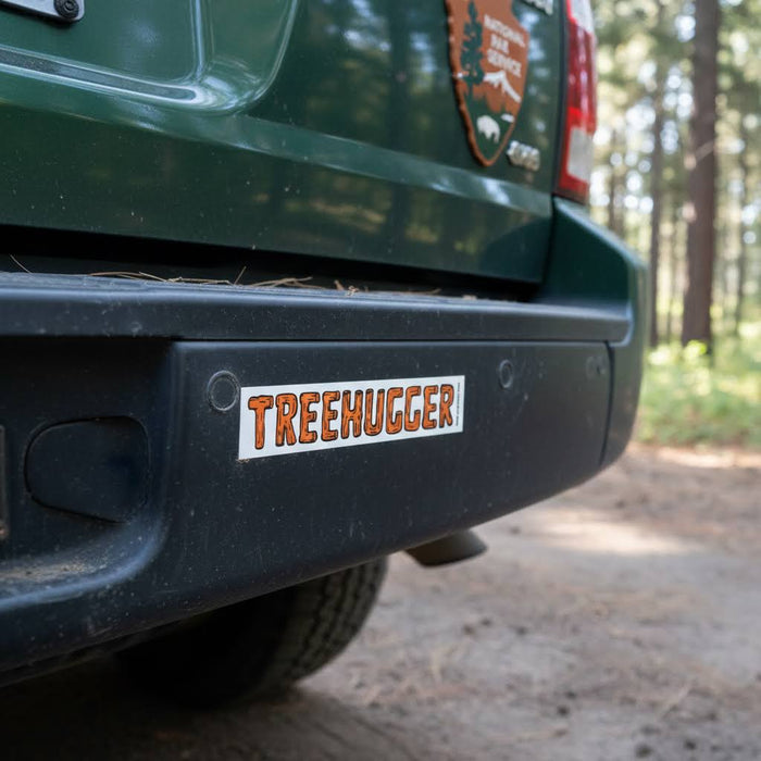 Forager Provisions LTD Tree Hugger vinyl sticker applied to a green vehicle bumper in a forest setting